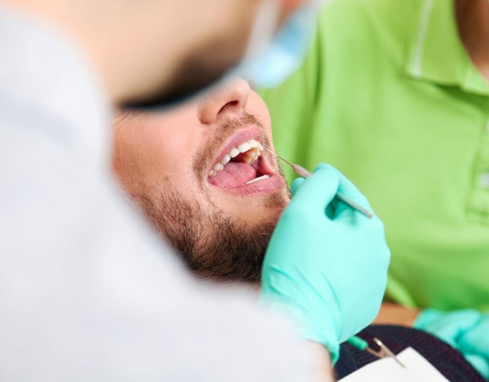 Dr. Weiser fährt mit Sonde an Zähnen entlang