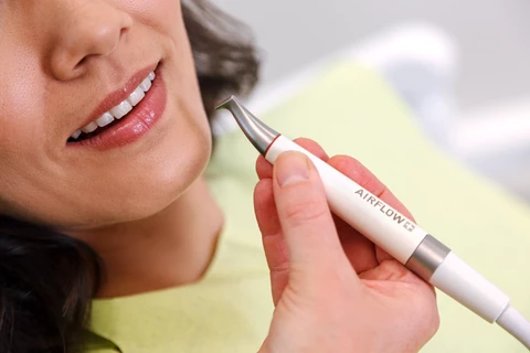 zahnarzt-praxis-weiser-duesseldorf-prophylaxe-pzr-airflow-2878_©Tilman_Schenk | Weiser Zahnmedizin Düsseldorf Nahaufnahme eines Airflow-Prophylaxe-Geräts vor dem Mund einer Patientin bei der professionellen Zahnreinigung